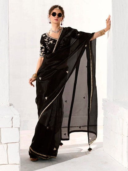 Dhiyona KM Women Royal Black Organza Saree With Black Embroidered Blouse “ A Symphony Of Power And Grace  Meta Description: