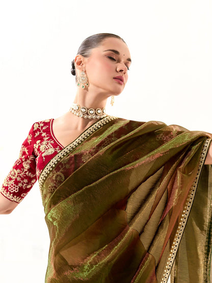 Dhiyona KM Women Mahendi Green Tissue Silk Saree With Red Blouse “ Inspired By Tradition & Bold Elegancemahendi Green Tissue Silk Saree With Red Blouse
