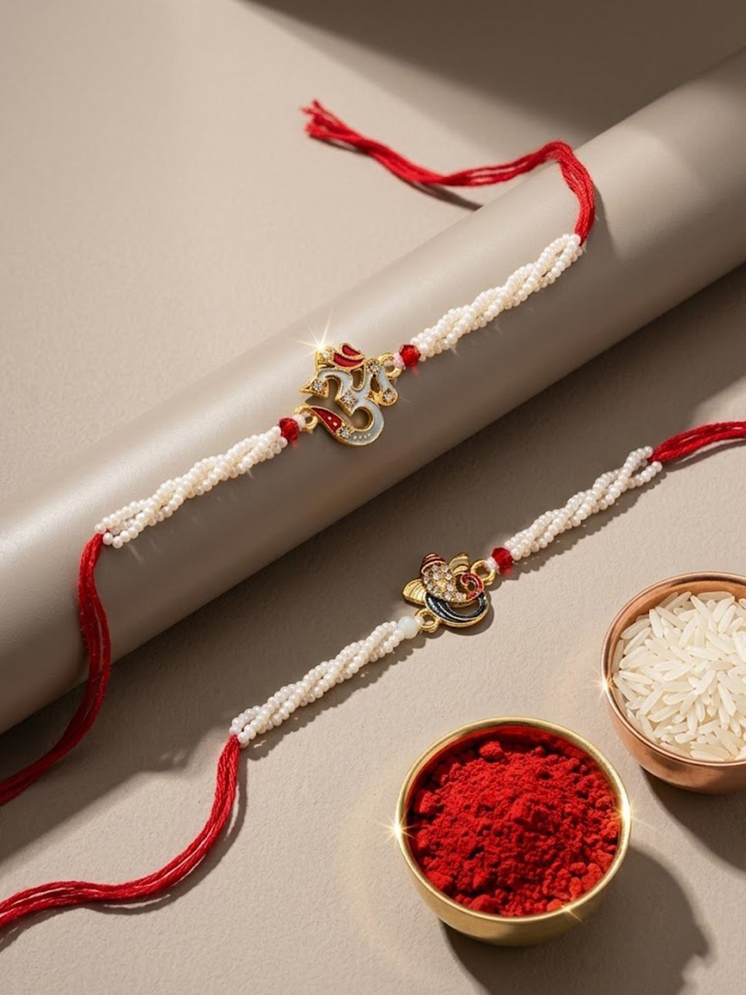 Dhiyona Set Of 2 White Pearls Om & Ganesh Ji Thread Rakhi With Roli Chawal Chandan Mishri