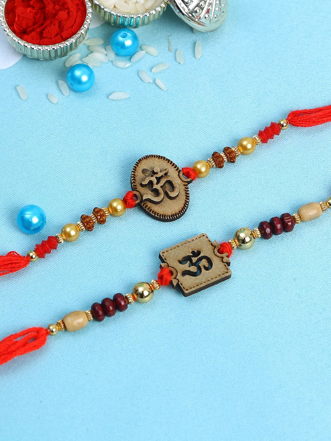 Dhiyona Set Of 2 Red Wooden Om Beaded Rakhi With Roli Rice & Greeting Card