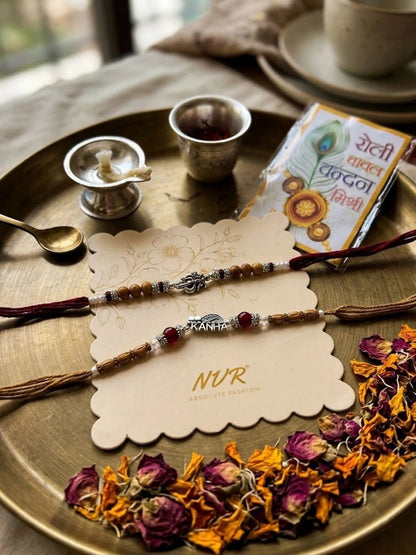 Dhiyona Set Of 2 Silver Toned Religious Rakhi Thread Rakhi Roli Chawal Chandan Mishri
