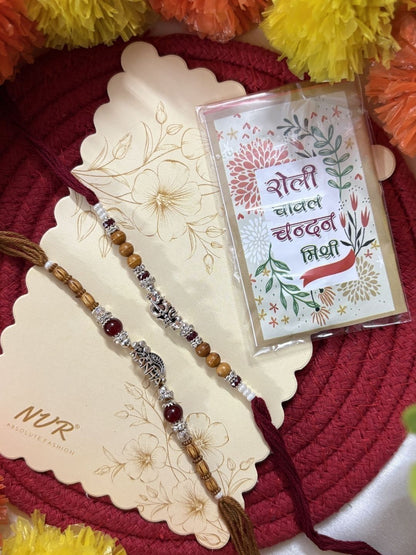Dhiyona Set Of 2 Silver Toned Religious Rakhi Thread Rakhi Roli Chawal Chandan Mishri
